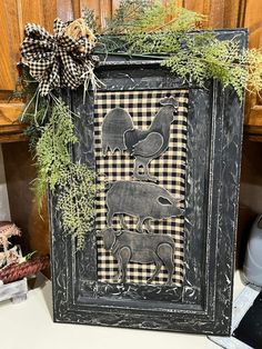 a black frame with an image of two elephants on it and a bow hanging from the front