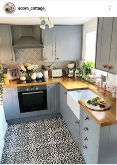 the kitchen is decorated in grey and white with wood countertops, tile flooring, and wooden counters