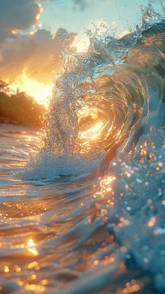 an ocean wave with the sun setting in the background and some water splashing on it