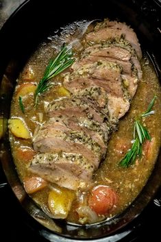 pork stew in a slow cooker with potatoes and carrots on the side, garnished with fresh herbs