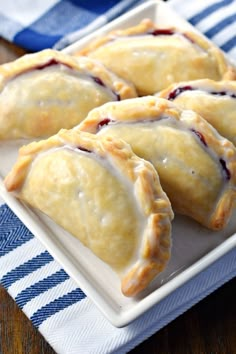 four pastries on a plate with blue and white napkins