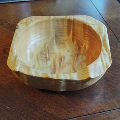 a wooden bowl sitting on top of a wooden table