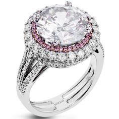 a white diamond ring with pink and white diamonds on the band, set in 18k white gold