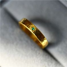 a close up of a gold ring with a green stone in it's center