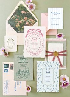 the wedding stationery is laid out on top of each other, including envelopes and cards