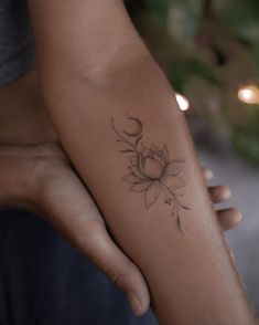 a woman's arm with a flower tattoo on the left side of her arm