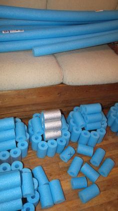 blue pipes are laid out on the floor next to some cushions and pillows in a living room