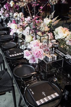 a long table with black plates and flowers