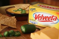 a box of velveeta sits next to some green peppers and tortilla chips