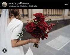 a bride holding a bouquet of red flowers