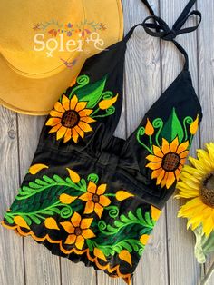 This Beautiful Sunflower Embroidered Halter Top is the perfect Top for Everyday use or a special event. It is comfortable, with elastic on the back and has a tie around the neck for an adjustable fit. This blouse comes in one size which fits sizes Small and Medium. Green Embroidered Top For Summer, Fitted Floral Embroidered Top For Festival, Fitted Summer Embroidered Top With Geometric Design, Fitted Summer Embroidered Top With Geometric Embroidery, Fitted Summer Top With Geometric Embroidery, Fitted Embroidered Top With Geometric Design For Summer, Intricate Embroidery Summer Festival Top, Summer Embroidered Top With Floral Print, Multicolor Embroidered Floral Top For Summer