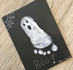 a halloween card with a ghost handprinted on it and white balls in the middle