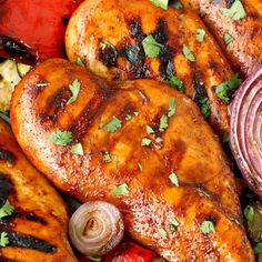 grilled chicken and vegetables on a platter with cilantro, onions, red onion, and parsley