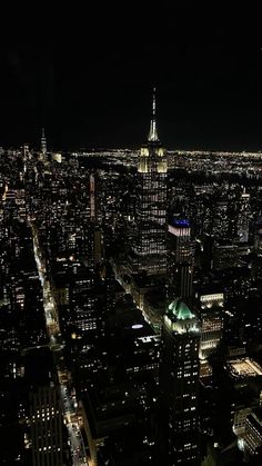 an aerial view of the city at night with skyscrapers lit up in green and white