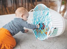 a baby is playing with a toy in the room and it looks like he's trying