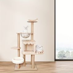 two white cats sitting on top of a cat tree