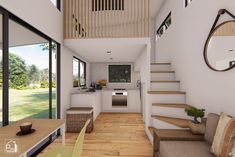 a living room filled with furniture next to a wooden table and stairs leading up to a kitchen