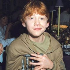 a young boy is dressed up as luke from star wars holding an object in his hands