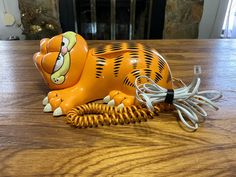 an orange tiger telephone sitting on top of a wooden table