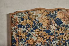 an old fashioned headboard with blue and yellow flowers on it