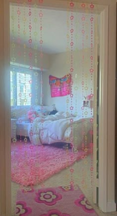 the bedroom is decorated in pink and white with beads hanging from the ceiling over the bed