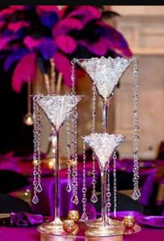 three crystal martini glasses on top of each other in front of a purple table cloth