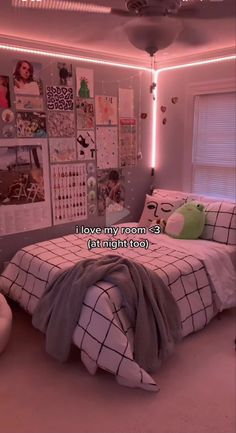 a bedroom with pink lights and pictures on the wall