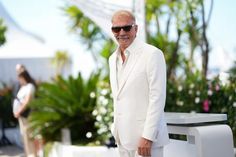 an older man in a white suit and sunglasses