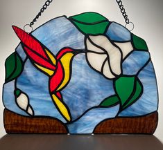 a stained glass bird hanging on a chain