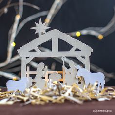 a nativity scene made out of cutout paper and string lights on a table