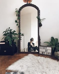 a mirror sitting on top of a wooden floor next to a white sheepskin rug