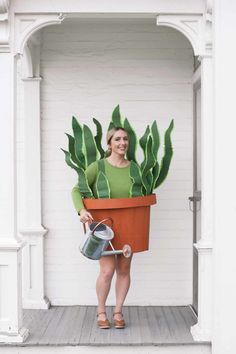 a woman holding a potted plant and watering can