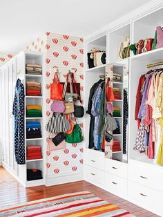 an organized closet with handbags and purses on the shelves in front of it