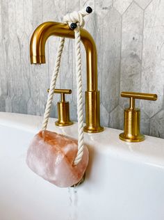 a rope wrapped around a faucet in a bathtub with soap on it