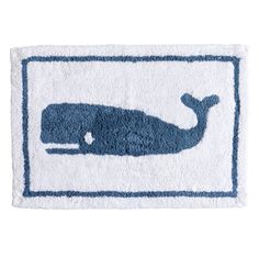 a bath mat with a blue whale on the front and white back ground, which has a light blue border around it