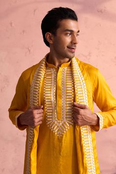 Shrestha by Vastramay - Men's Yellow Silk Kurta Pyjama Set Luxuriate in this elegant yellow silk kurta pyjama set featuring intricate machine embroidery. Perfect for festive occasions or special events. Key Features Yellow silk kurta with machine embroidery on neckline Mandarin collar, long sleeves, side slits, and pockets Cream colored pyjama with elasticated waistband Yellow embroidered silk dupatta Specifications Kurta Length: Knee Length Material & Care Top Fabric: Silk Blend Bottom: Cream c Kurta Pyjama, Silk Kurta, Yellow Silk, Dupatta Set, Silk Dupatta, Sleeveless Jacket, Fabric Silk, Full Sleeves, Pyjama Set