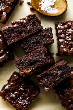 chocolate brownies are stacked on top of each other with a spoon in the background