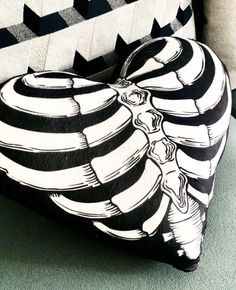 a black and white heart shaped pillow sitting on top of a couch