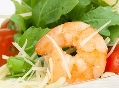 a salad with shrimp, lettuce and tomatoes