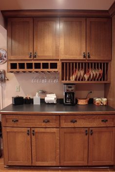 a kitchen with wooden cabinets and stainless steel counter tops, coffee maker on the far wall