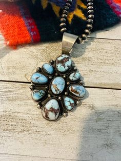 a necklace with turquoise stones is sitting on a wooden table