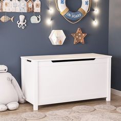 a toy chest in a child's room with lights on the wall above it