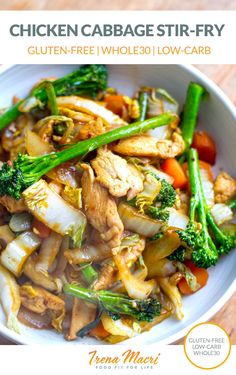 a white bowl filled with meat and veggies on top of a wooden table