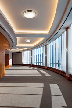 an empty room with large windows and wooden paneling