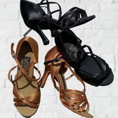 three pairs of women's shoes hanging on a brick wall