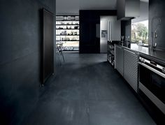 an empty kitchen with black walls and flooring