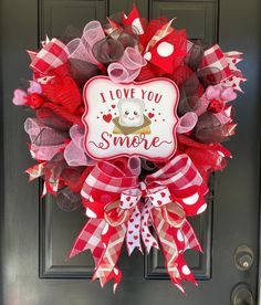 a red and white wreath that says i love you smore on the front door