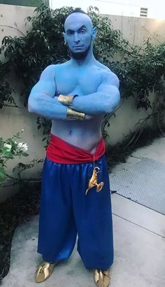 a man dressed in blue and gold stands with his arms crossed while posing for the camera