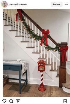 the stairs are decorated with red bows and garlands for christmas, along with an old fashioned mailbox