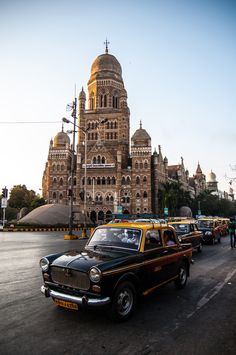 an old car is driving down the street in front of a large building with a dome